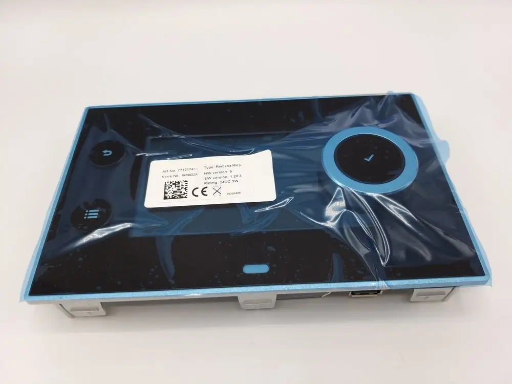 Remeha Bedienelement im Kunststoffschutz, schwarze Oberfläche mit blauen Akzenten, inklusive Tasten für Funktionen und Anzeige, auf einer flachen Basis montiert.